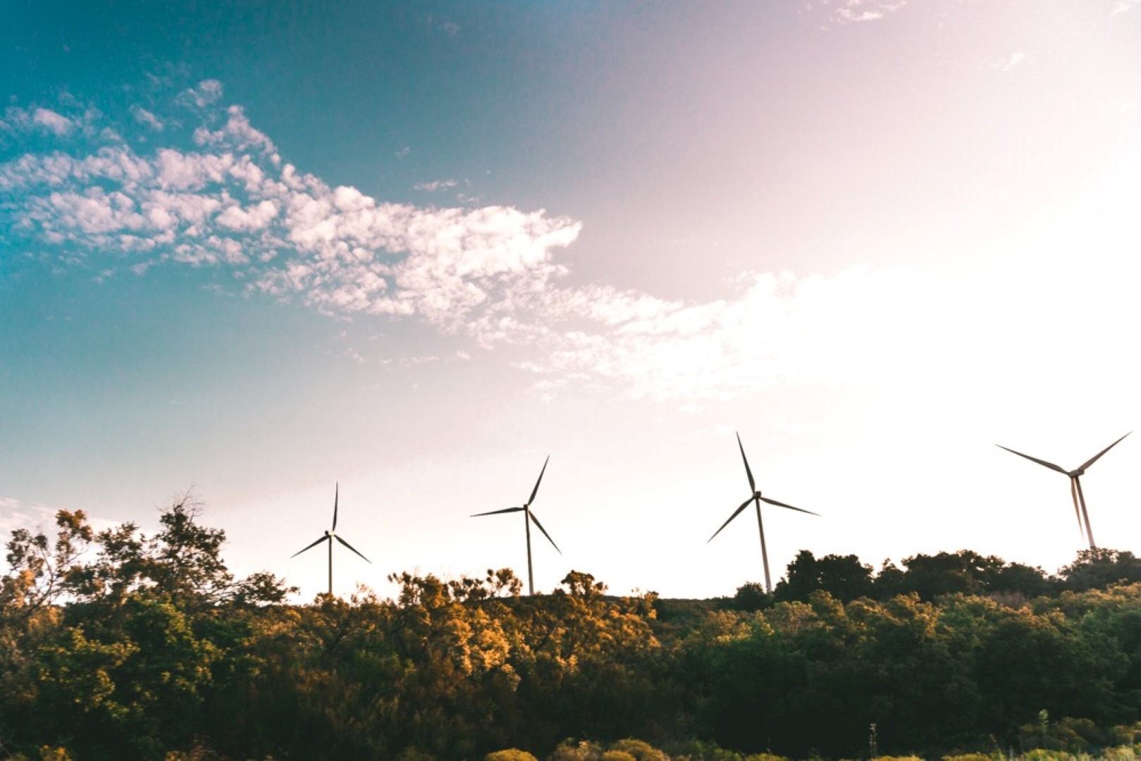 Winddelen met windmolens in een landschap als voorbeeld van duurzame energieopwekking zonder eigen installatie.